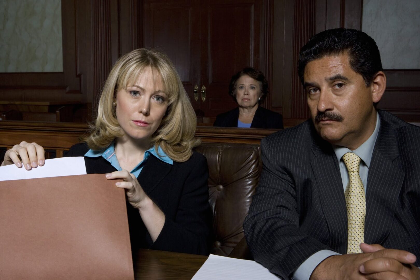Portrait of two multiethnic lawyer sitting with woman in the background